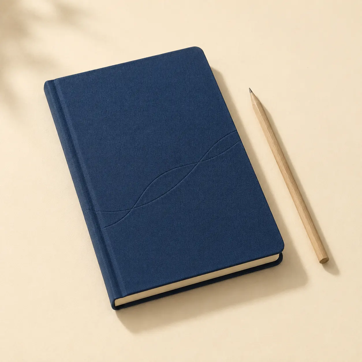 Deep indigo clothbound field notebook beside a natural wood pencil
