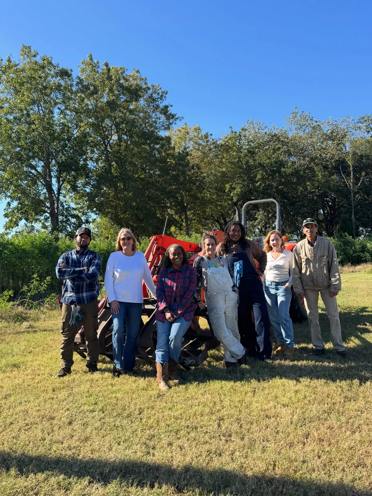 The harvest crew standing together beside a tractor in the indigo field.
