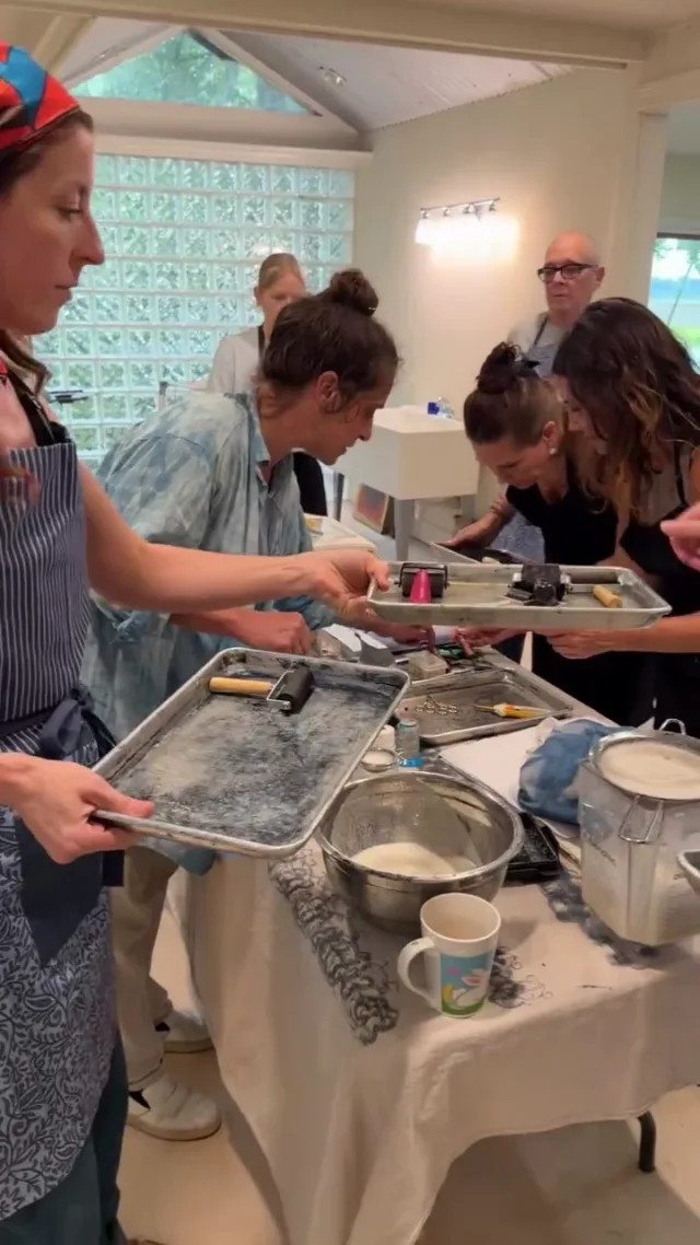 Artists gathered around a shared table, exploring textile techniques together.